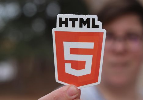 Man Holding a Paper Cutout with the HTML5 Logo