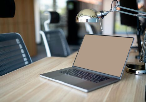 Laptop lying on the desk. Office spaces.