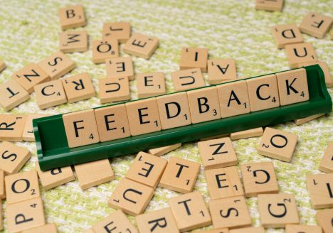 The word feedback is spelled out with scrabble tiles