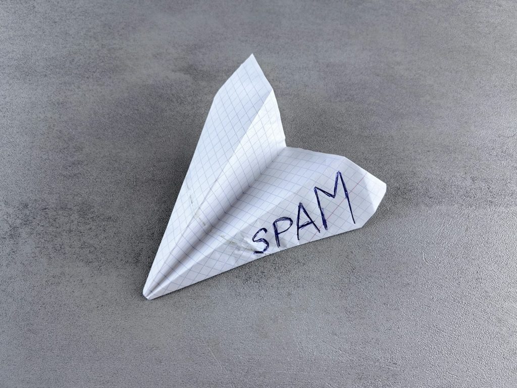 a paper airplane with the word spam written on it