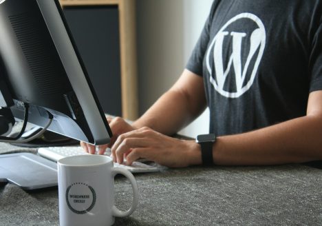 person in black and white t-shirt using computer